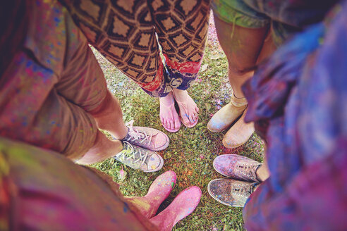Draufsicht auf junge Erwachsene in einem mit farbigem Kreidepulver bedeckten Kreis auf einem Festival - ISF01659