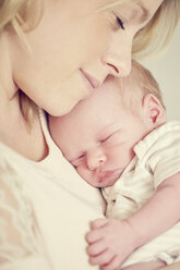 Newborn baby boy, sleeping in mother's arms, close-up - CUF07734