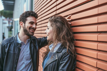 Couple chatting by orange wall, Florence, Italy - CUF07836