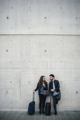 Ehepaar mit Gepäck, grauer Wandhintergrund, Florenz, Italien - CUF07839