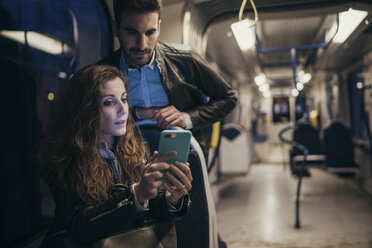 Ehepaar benutzt Mobiltelefon im Zug, Florenz, Italien - CUF07842