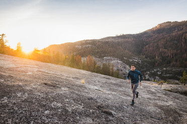 Mann läuft bei Sonnenuntergang über Felsen, Yosemite National Park, Kalifornien, USA - CUF07871