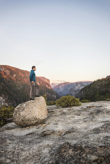 Mann schaut von der Spitze eines Felsblocks aus, Yosemite National Park, Kalifornien, USA - CUF07872