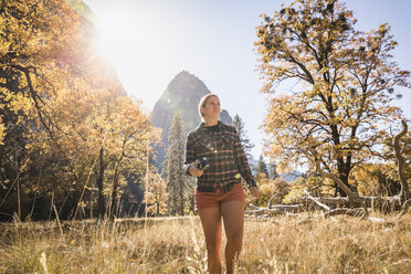 Frau mit Kamera in Herbstlandschaft, Yosemite National Park, Kalifornien, USA - CUF07876