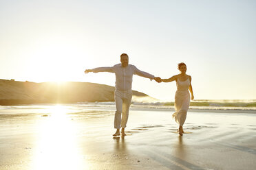 Mature couple walking along beach, hand in hand, Cape Town, South Africa - CUF07925