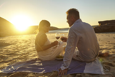 Couple drinking red wine on beach - CUF07930