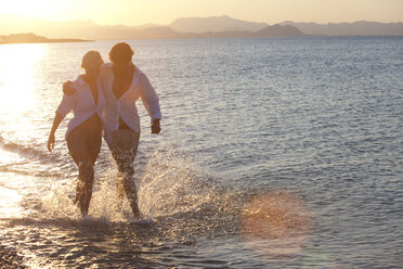 Paar geht im flachen Ende des Meeres spazieren - CUF07959