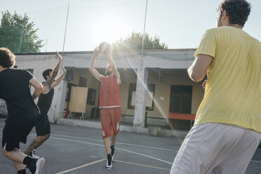 Friends on basketball court playing basketball game - CUF07970
