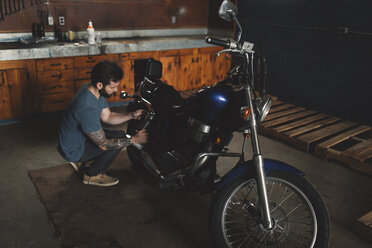 Mann repariert Fahrrad in Werkstatt - ISF01703