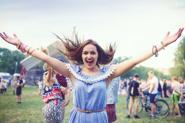 Young boho woman dancing and jumping for joy at festival - ISF01762