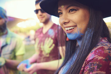 Young boho woman with blue chalk powder on chin at festival - ISF01775