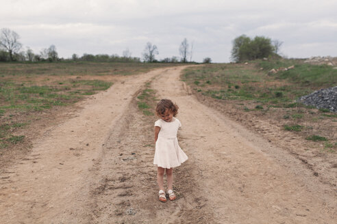 Porträt eines schüchternen Mädchens auf einem ländlichen Feldweg - ISF01819