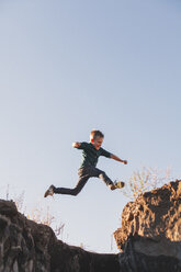 Junge springt in der Luft über Klippen - ISF01824