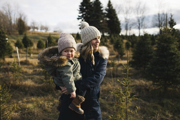 Mother and baby girl in Christmas tree farm, Cobourg, Ontario, Canada - ISF01826