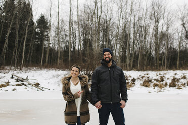 Glückliches Paar auf zugefrorenem See, Whitby, Ontario, Kanada - ISF01838