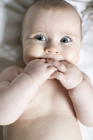 Porträt eines kleinen Mädchens, Finger im Mund, Draufsicht, lizenzfreies Stockfoto