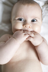 Portrait of baby girl, fingers in mouth, overhead view - ISF01893