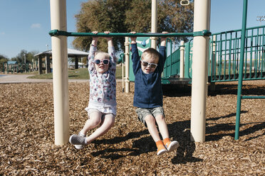 Junge und Mädchen hängen am Klettergerüst auf dem Spielplatz - ISF01909