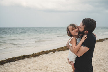 Father kissing daughter on beach, Cancun, Mexico - ISF01916