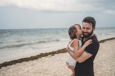 Father kissing daughter on beach, Cancun, Mexico - ISF01917