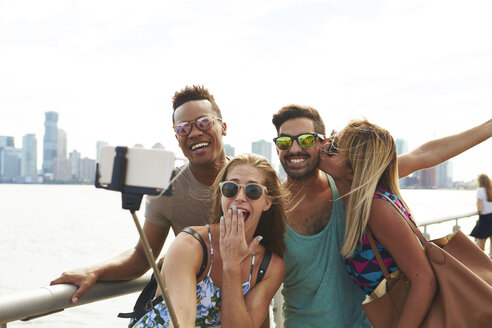 Vier erwachsene Freunde posieren für ein Smartphone-Selfie am Wasser mit Skyline, New York, USA - ISF01943