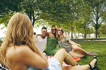 Blick über die Schulter einer Frau, die Freunde beim Picknick im Park fotografiert - ISF01949