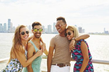 Portrait of four adult friends on waterfront with skyline, New York, USA - ISF01965