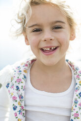 Porträt eines niedlichen blonden Mädchens mit fehlendem Zahn an der Küste - ISF01988