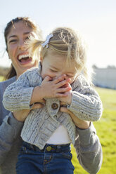 Female toddler being held up by laughing mother - ISF02000