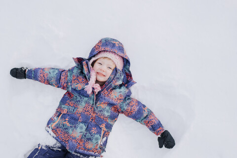 Mädchen liegend im Schnee, lizenzfreies Stockfoto