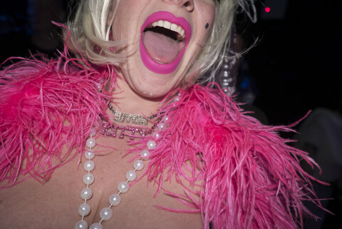 Mittlere erwachsene Frau in Partykleidung, mit rosa Federboa und rosa Lippenstift, mittlerer Ausschnitt, lizenzfreies Stockfoto