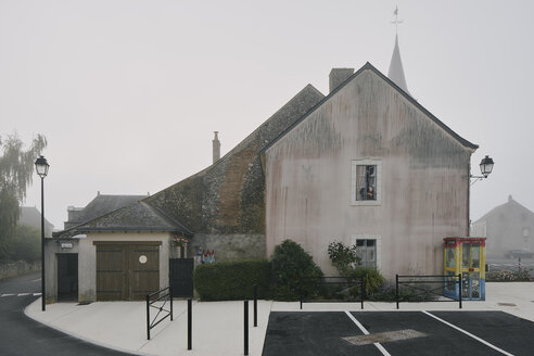 Hausgiebel und Parkplatz im Dorf Meigne-le-Vicomte an einem nebligen Morgen, Loiretal, Frankreich - CUF08147