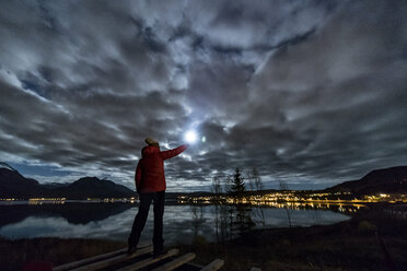 Frau mit Taschenlampe bei Tromso im Herbst, arktisches Norwegen - CUF08219
