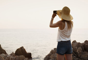 Rückansicht einer Frau, die mit einem Fernglas aufs Meer schaut, Ciutadella, Menorca, Spanien - CUF08222