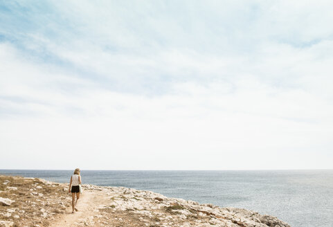 Frau geht auf Klippe, Menorca, Spanien - CUF08223