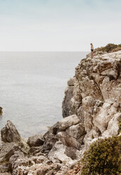 Frau auf Klippe stehend, Menorca, Spanien - CUF08224