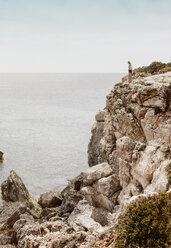 Woman standing on cliff, Menorca, Spain - CUF08224