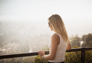 Frau auf Balkon mit Blick auf Malaga, Spanien - CUF08235