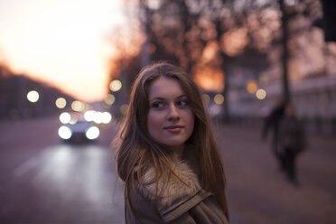 Young woman in street, traffic in background, London, UK - CUF08245