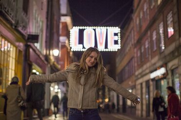 Junge Frau genießt die Weihnachtsbeleuchtung, Carnaby Street, London, UK - CUF08249