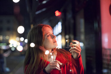 Junge Frau genießt die hellen Lichter der Straße, London, UK - CUF08254