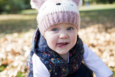 Portrait of female toddler with tongue out in park - CUF08329