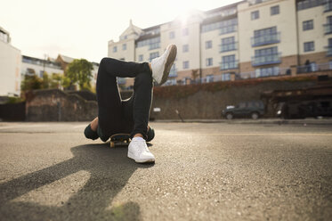 Junger Mann auf dem Skateboard liegend, entspannend, Bristol, UK - CUF08370