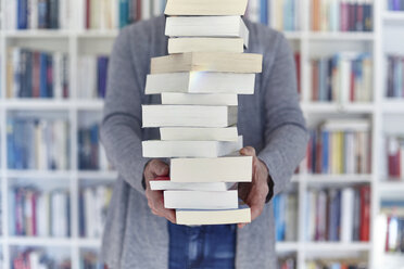 Woman holding stack of books, mid section - CUF08407