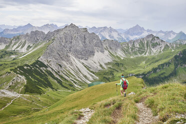 Rückansicht einer Wanderin beim Abstieg ins Tal in den Tannheimer Bergen, Tirol, Österreich - CUF08412