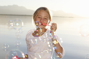 Junges Mädchen, im Freien, beim Blasen von Seifenblasen - CUF08435