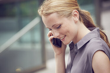 Woman using mobile phone in street, London, UK - CUF08471