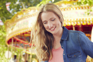 Women smiling, carousel in background, London, UK - CUF08484