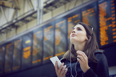 Woman looking at departure information, London, UK - CUF08487
