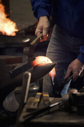 Farrier forging horseshoe on anvil - CUF08586